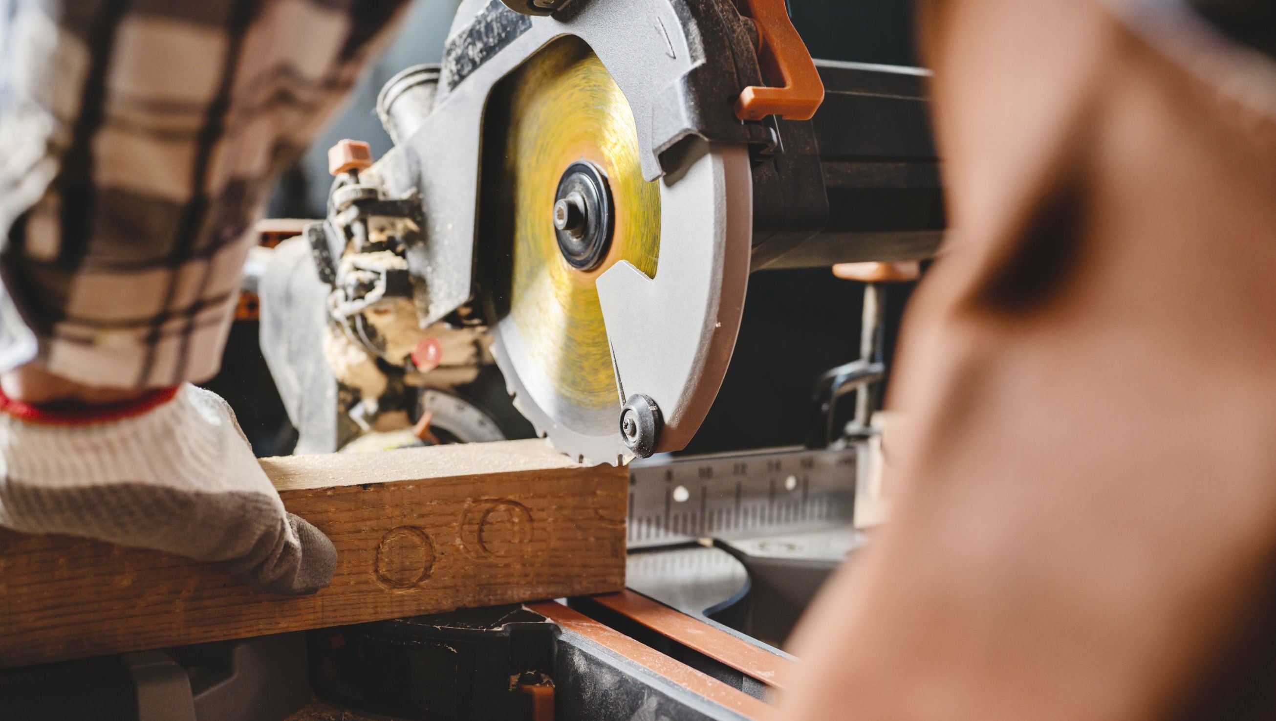 Snekker bruker kappsag for å kappe planke